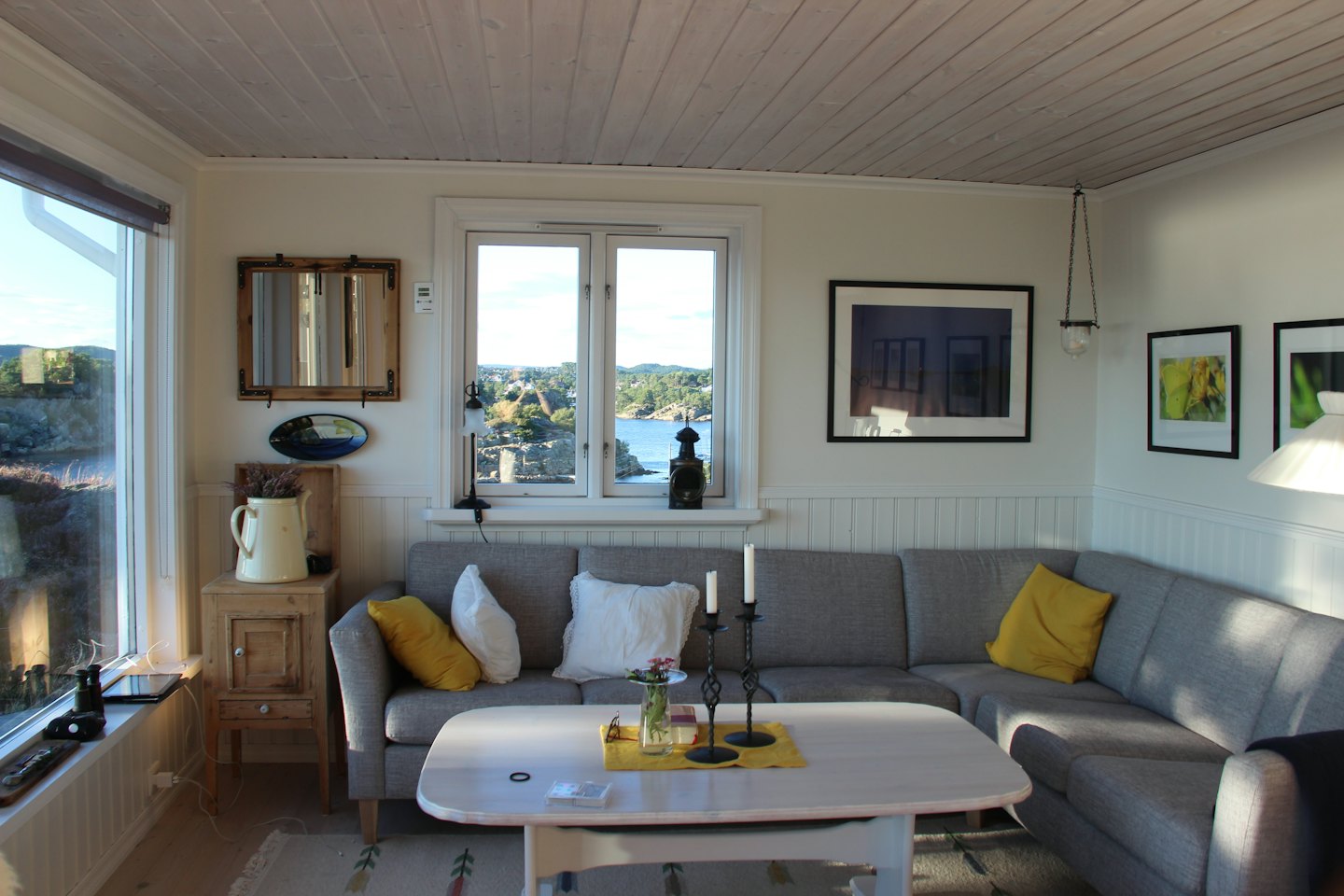 Living room with L-shaped sofa and ocean view.